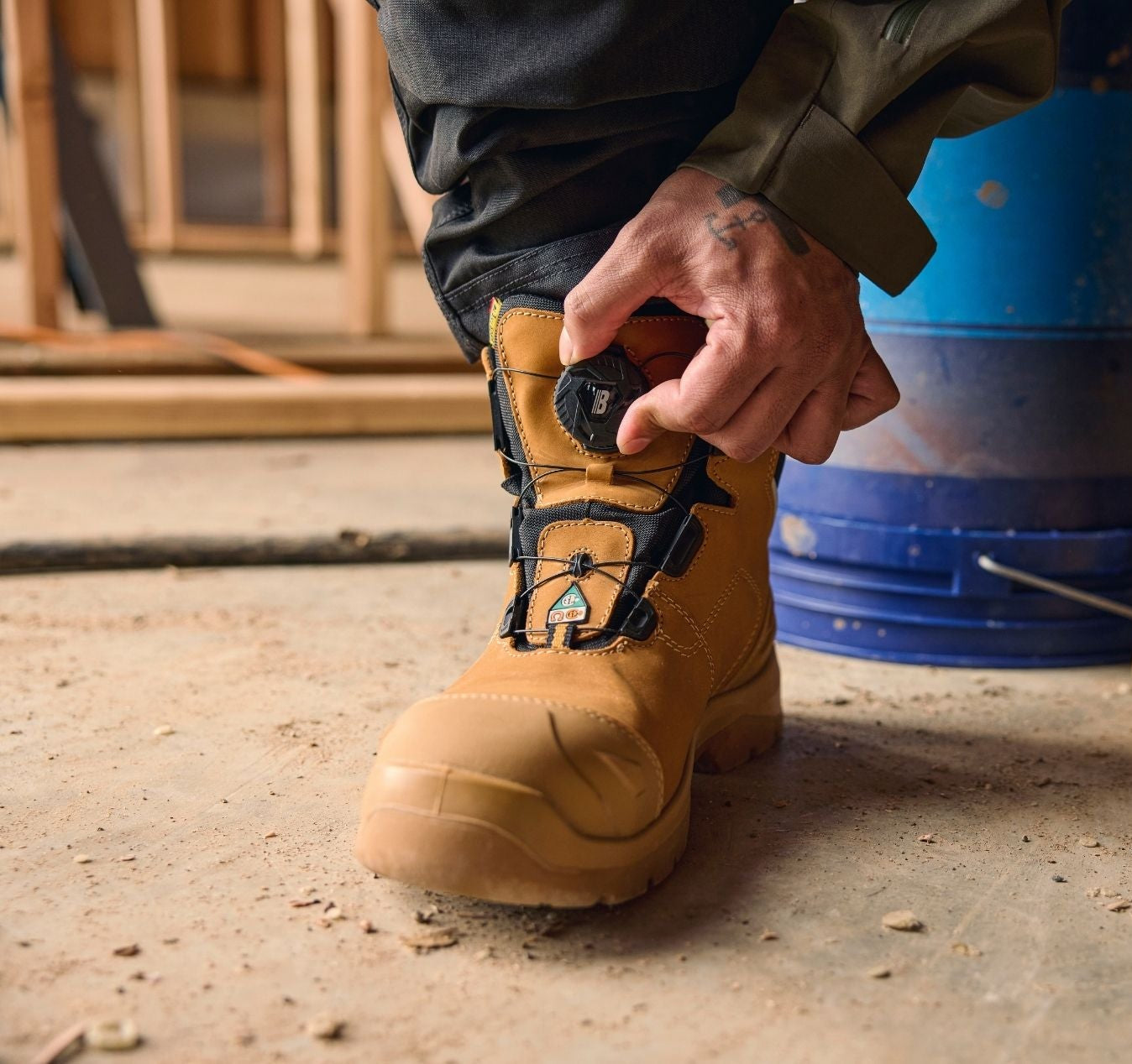 Blaklader Elite 6 Inch Freelock Safety Boot in Wheat with quick lacing system being adjusted by tradesperson on job site