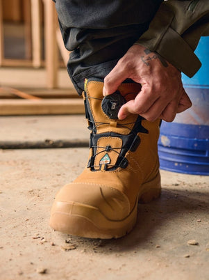 Blaklader Elite 6 Inch Freelock Safety Boot in Wheat with quick lacing system being adjusted by tradesperson on job site