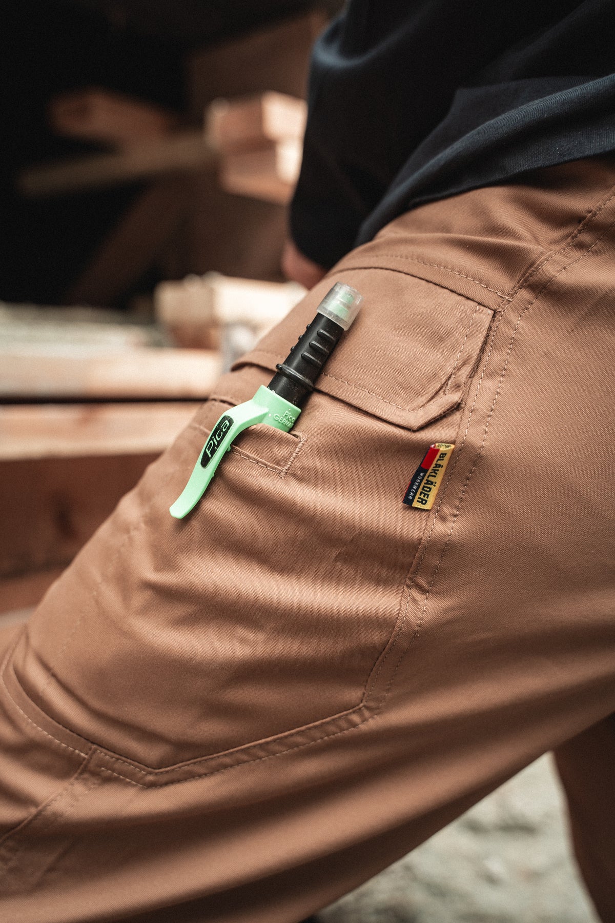 Pocket detail of tradesman wearing Ether Lite Pants in color Nougat