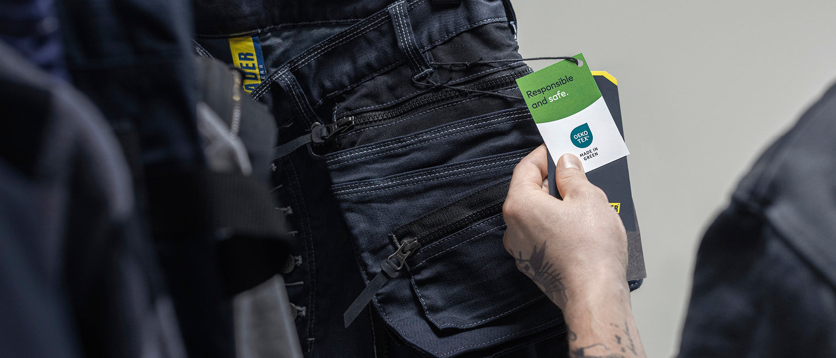 Person holding a smartphone with a screen displaying a product image, wearing dark jeans.